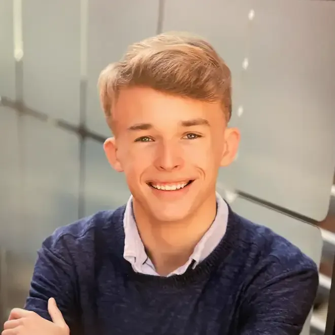 Nathan Gamache, smiling, in a navy sweater over a collared shirt